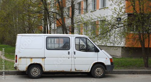 An old rusty white minibus parked on the road, Shotman Street, St. Petersburg, Russia, May 2022