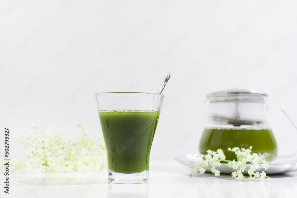 Un vaso de té verde matcha sobre una mesa blanca Un vaso de té verde matcha sobre una mesa blanca