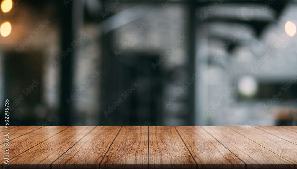 Empty wooden table top with lights bokeh on blur restaurant background.	

