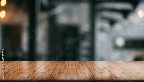 Empty wooden table top with lights bokeh on blur restaurant background.   © DEEP PIXEL