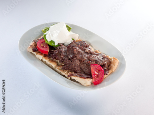 Turkish kebab and garnish on pita bread, Bursa İskender kebab