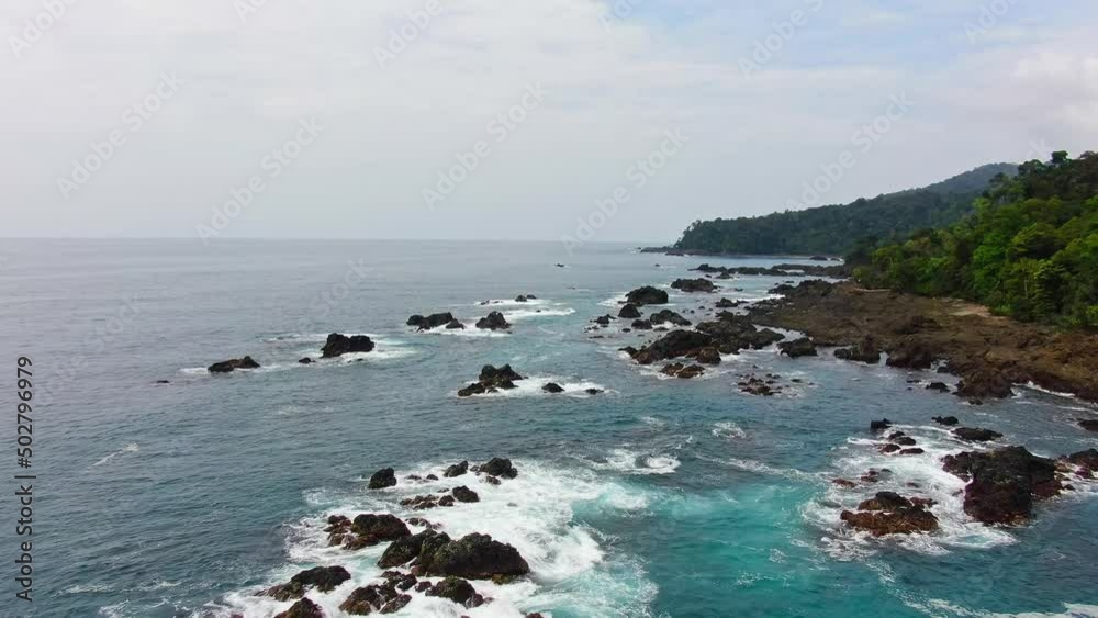 Clear Blue Ocean Waves Breaking On Coastal Rocks In Pacific Coast Of Colombia, South America. 4K Drone Aerial Footage. Clear Blue Ocean Waves Breaking On Coastal Rocks In Pacific Coast Of Colombia, South America. 4K Drone Aerial Footage.