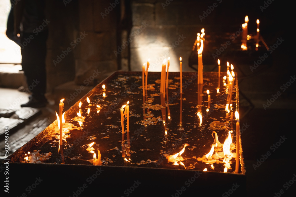Fototapeta Burning candles in a church.