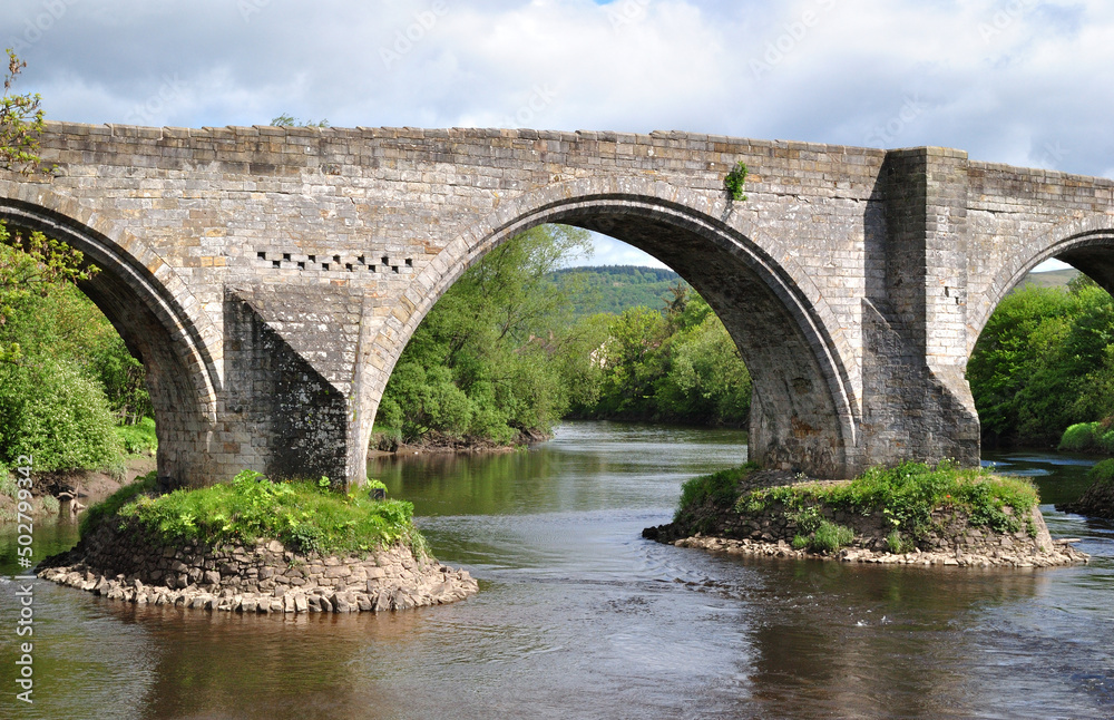 View of Ancient Stone Bridge and River on Sunny Day 