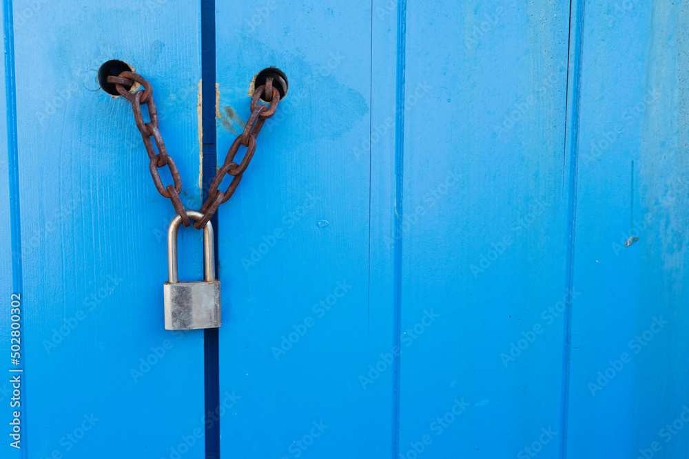 Lock on a blue door with a chain on the right there is a place for an Lock on a blue door with a chain on the right there is a place for an