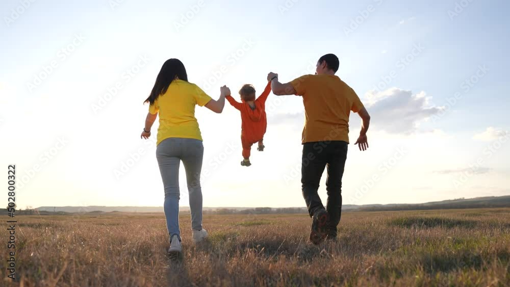happy family. parent a baby together run in the park at sunset. people in park concept. mom dad daughter and son swing on hands joyful run. happy family and baby child summer kid fun dream concept happy family. parent a baby together run in the park at sunset. people in park concept. mom dad daughter and son swing on hands joyful run. happy family and baby child summer kid fun dream concept