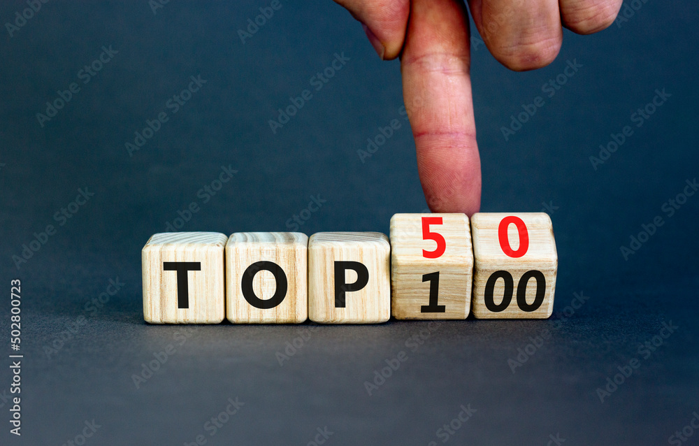From Top 100 to 50 symbol. Businessman turns wooden cubes and changes ...
