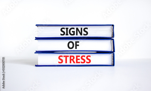 Signs of stress symbol. Concept words Signs of stress on books. Beautiful white table white background. Psychological business and signs of stress concept. Copy space.