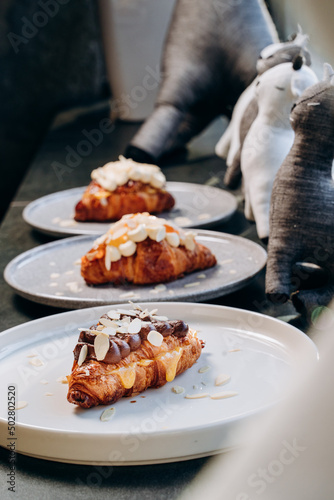 Croissant with jam, croissant with chocolate, croissant with vanilla cream on a plate. Delicious breakfast and dessert.