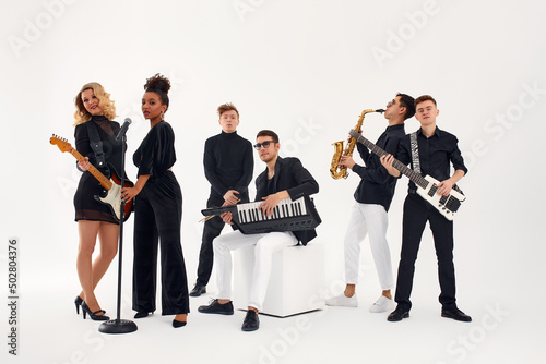 Картината върху платно Portrait of diverse group of young people musical band playing with instruments - isolated on white background
