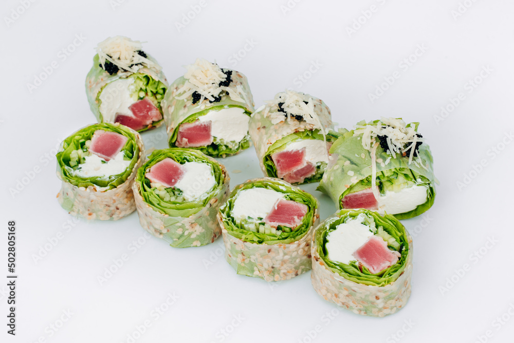 sushi rolls in lettuce with tuna salmon and cheese on a white background. restaurant menu. sushi rolls in lettuce with tuna salmon and cheese on a white background. restaurant menu.
