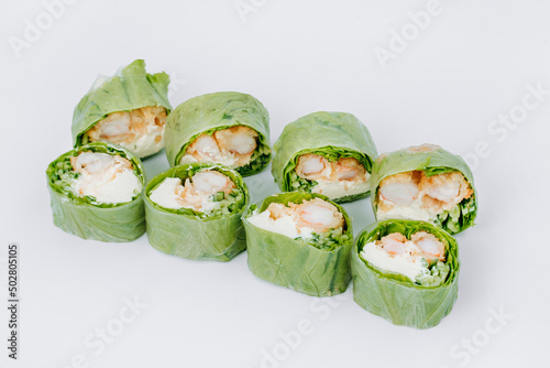 sushi rolls in lettuce with tuna salmon and cheese on a white background. restaurant menu.