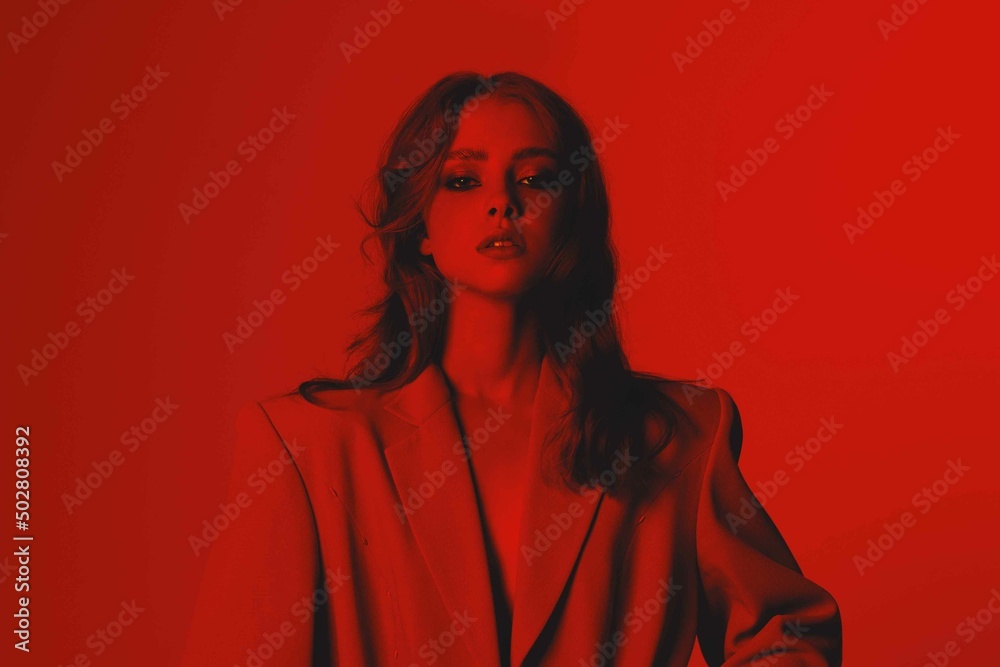 High-fashion. Young beautiful woman with wavy hair in red light. Sexy girl in a jacket. Creative colorful monochrome fashion portrait of Generation Z - obrazy, fototapety, plakaty 