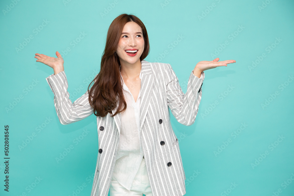 Happy Asian businesswoman open hand palm with copy space for product isolated on green background Happy Asian businesswoman open hand palm with copy space for product isolated on green background