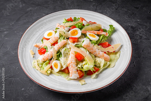 fresh salad with shrimp and parmesan on a black background