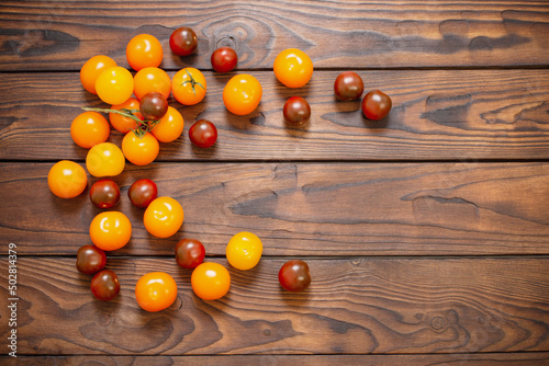 various tomatoes on dark wooden table