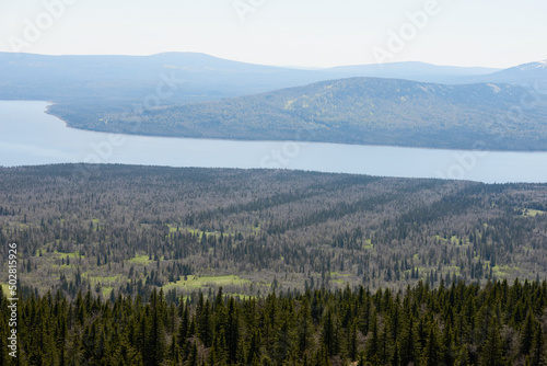 National park, the Urals, Russia. Aerial view of vast wild forest, green hills and wide river passing through