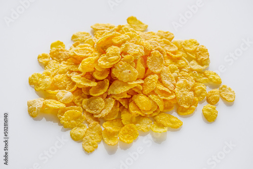 crispy golden cornflakes on a white acrylic background