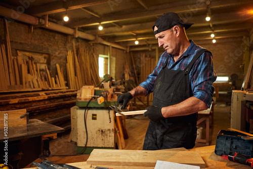 Senior Professional carpenter working with caliper in the carpentry workshop