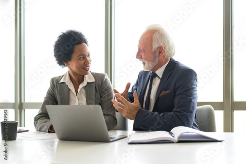 Multicultural team discusses business strategy. Smiling businesswoman talks to an experienced manager who advises her on the necessary corrections in the business plan