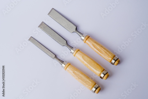 Chisel and shavings isolated on white background. Carving hand tools or chisels on a white background. Chisel with wooden handle on the white background. Work tool chisel isolated on white background photo