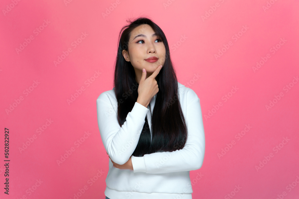 Thoughtful dreaming asian young girl touching chin, lost in thoughts, looking up, planning future, visualizing dreams Thoughtful dreaming asian young girl touching chin, lost in thoughts, looking up, planning future, visualizing dreams