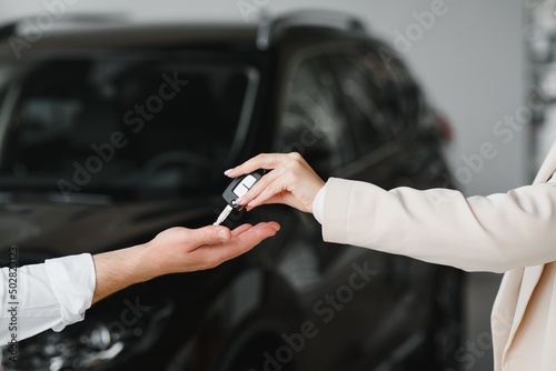 businessman exchange handing over the car keys for to a young women.