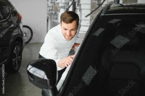 Man buying a car at a showroom © Serhii