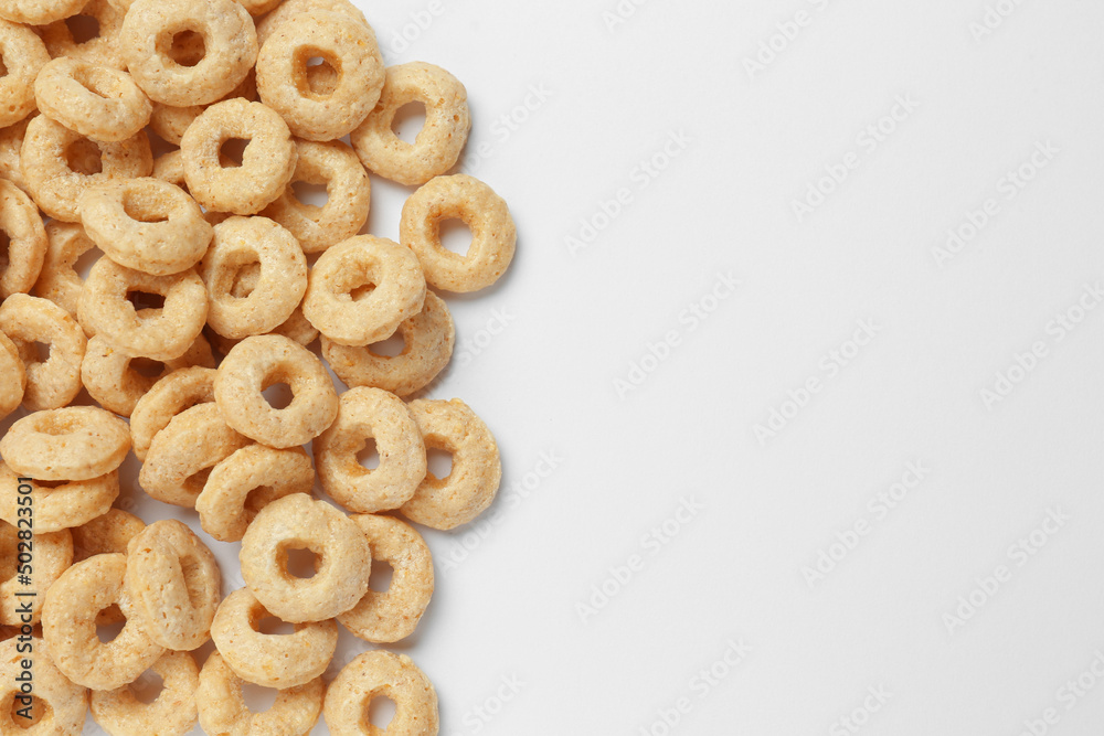 Sweet tasty corn rings on white background, top view