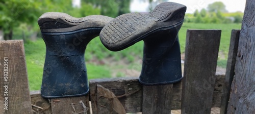 Boots on the fence. Country style. Ukrainian village. Private house, garden. Wonderful nature, forest.