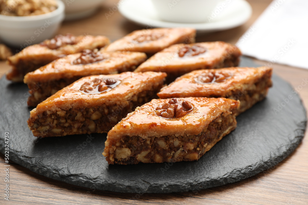Delicious sweet baklava with walnuts on wooden table, closeup