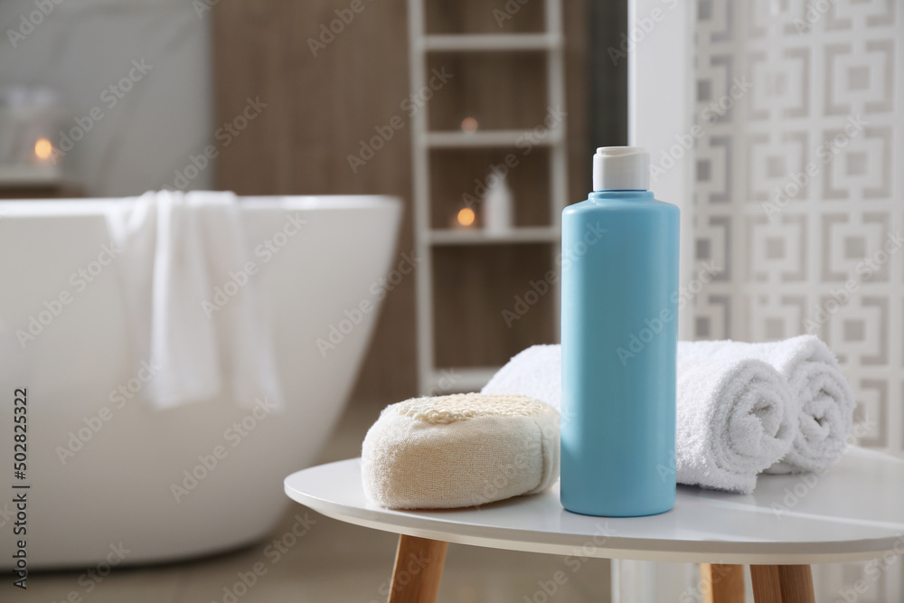 Bottle of shower gel, sponge and fresh towels on white table in bathroom. Space for text Bottle of shower gel, sponge and fresh towels on white table in bathroom. Space for text