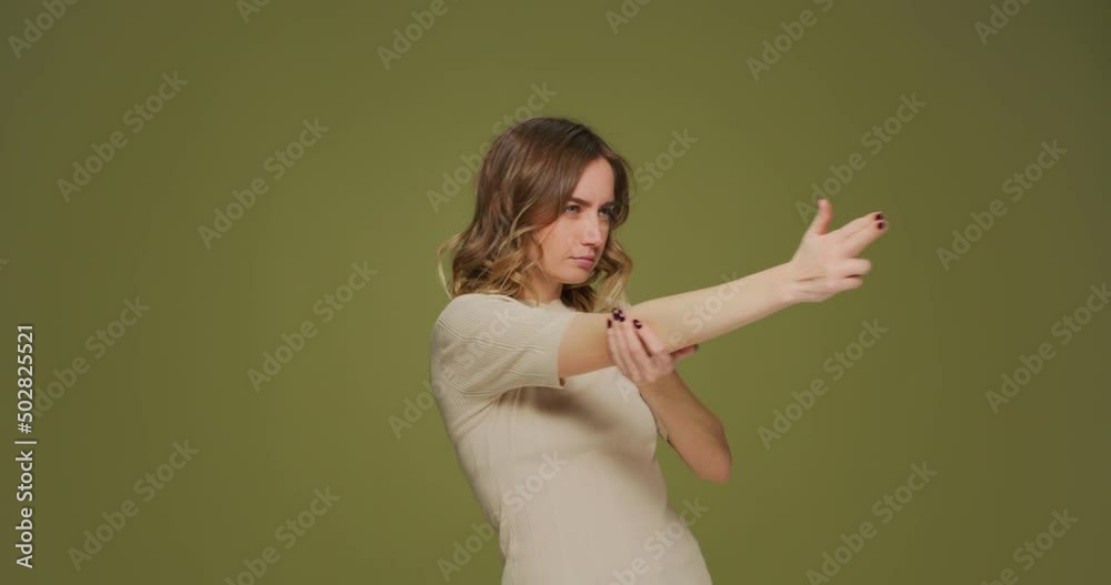 Serious young woman make gun gesture, searching for target, point by finger, shooting with hand pistol to camera Serious young woman make gun gesture, searching for target, point by finger, shooting with hand pistol to camera