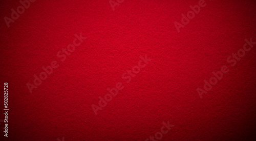 Photo of a fabric texture of crimson red color . The background is dark red with a black vignette. The texture of the felt fabric for the inscription.