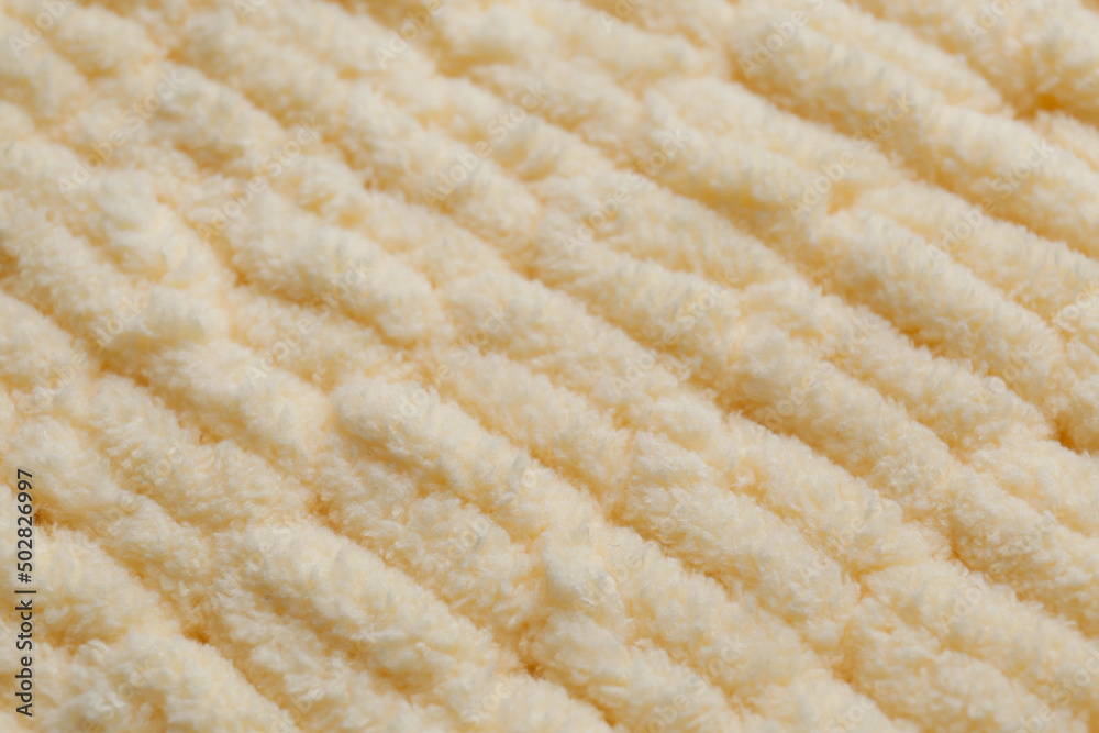 Soft beige knitted fabric as background, closeup Soft beige knitted fabric as background, closeup