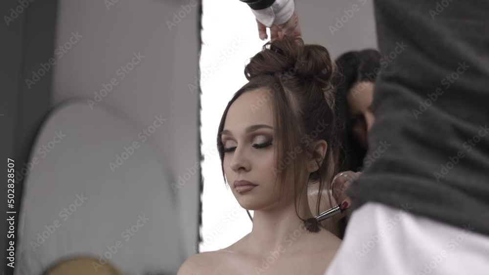 Make up artist and hair dresser getting beautiful girl model ready for the shoot 4K Make up artist and hair dresser getting beautiful girl model ready for the shoot 4K