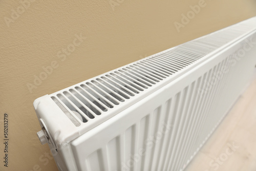 Wallpaper Mural Modern radiator on beige wall, closeup. Central heating system Torontodigital.ca