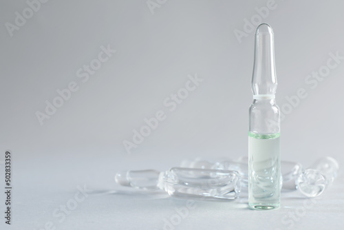 Pharmaceutical ampoules with medication on light grey background. Space for text photo