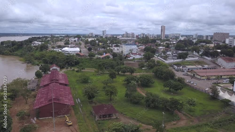 Aerial drone view of Porto Velho city center streets skyline. Praça das três caixas d água square, Madeira river and Amazon rainforest in the background on cloudy winter day. Rondonia state, Brazil.