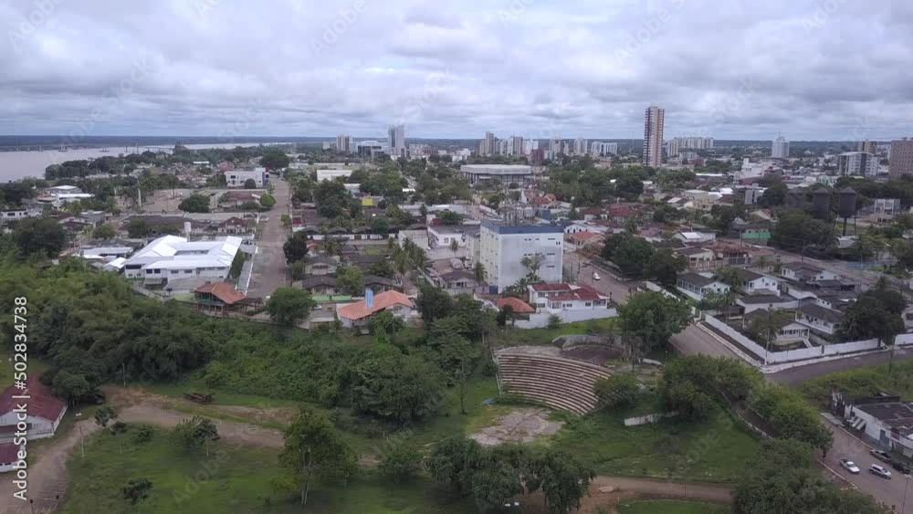 Aerial drone view of Porto Velho city center streets skyline. Praça das três caixas d água square, Madeira river and Amazon rainforest in the background on cloudy winter day. Rondonia state, Brazil.
