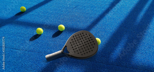Close up of a padel ball and racket on a blue syntehtic playground	