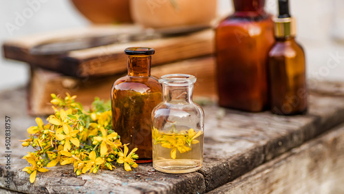 Hypericum perforatum, St. John's wort apothecary bottles with tincture and essential oils for beauty salons and alternative medicine photo