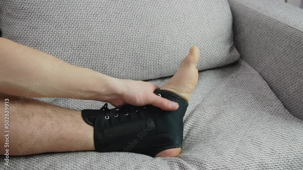 compression fixed in ankle stabilizer medical bandage. Fracture or Leg sprain injury of young sports man. Lacing and tight fit of the foot. Post-fracture therapy and development. 