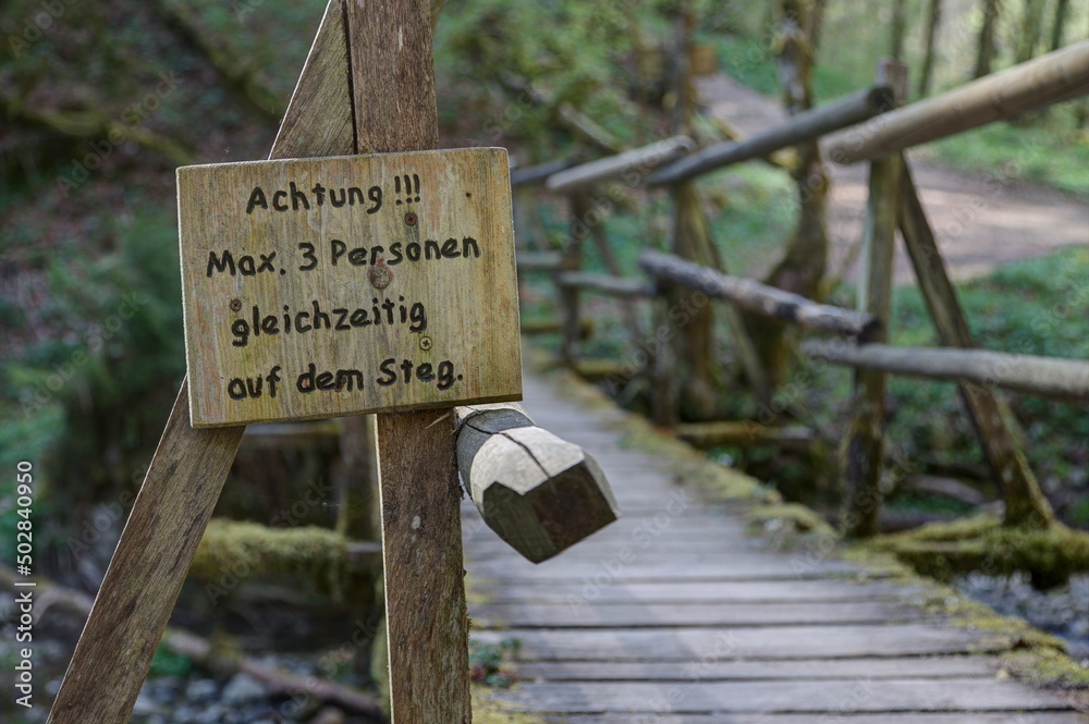Wooden walkway in the Gauchach Gorge with a sign saying 