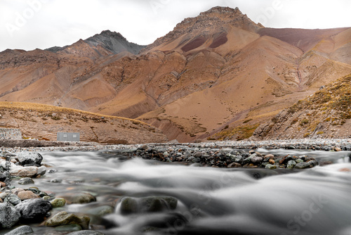 Horizontal shot of the Rio Yeso with silk effect and mountains in the background in Cajon del Maipo, Chile. photo