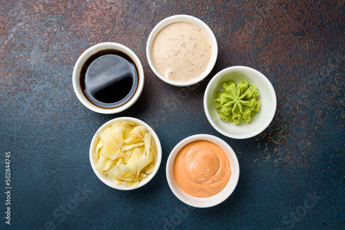 assorted sauces with ginger and wasabi top view on blue concrete table