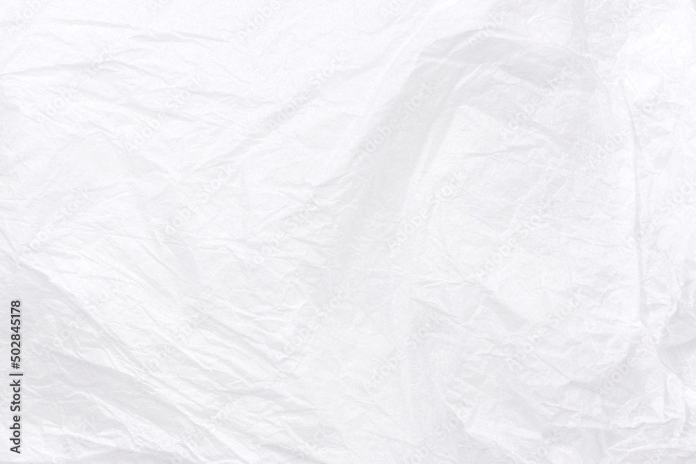 Abstract background of textural crumpled white paper. Wrapping paper randomly crumpled texture close-up. Can be used as background or overlay.