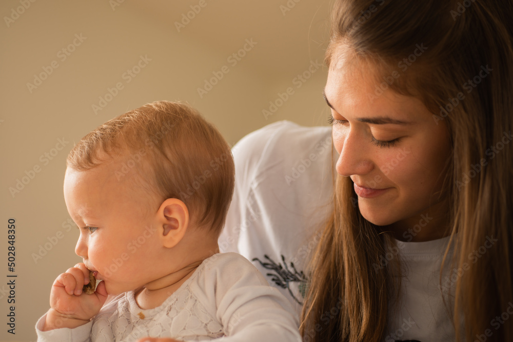 Mother is watching her baby eat Mother is watching her baby eat