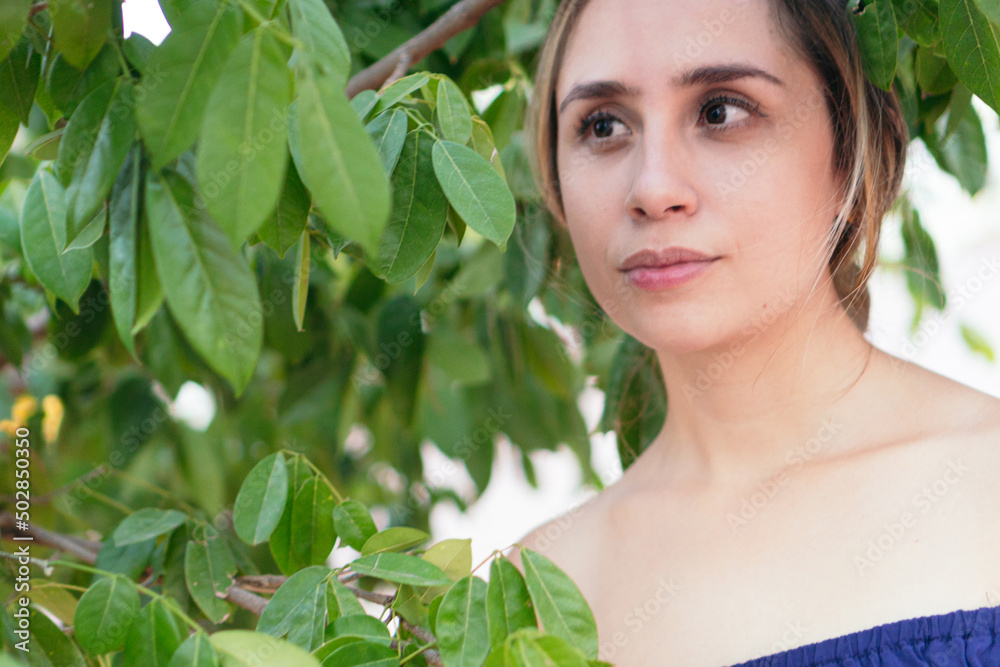 Latin woman poses while surrounded by a variety of plants in a lush green park Latin woman poses while surrounded by a variety of plants in a lush green park