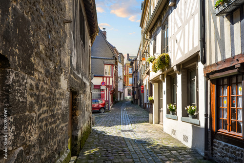 A picturesque narrow street alley in the medieval village of Honfleur, France, in the Normandy region.